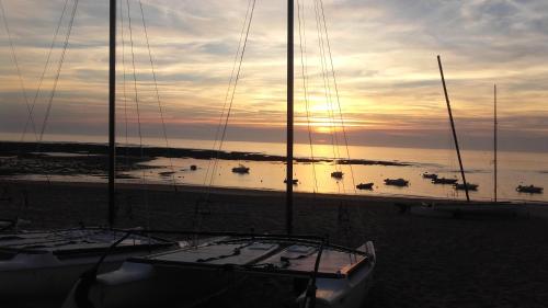a group of boats sitting on the beach at sunset at Maison avec Jardin privé in Saint-Hilaire-de-Riez