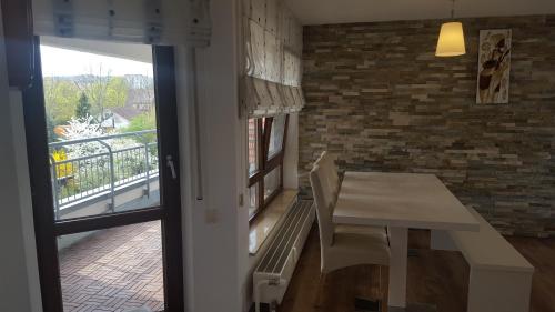 a table and chairs in a room with a balcony at City Home 1 in Metzingen