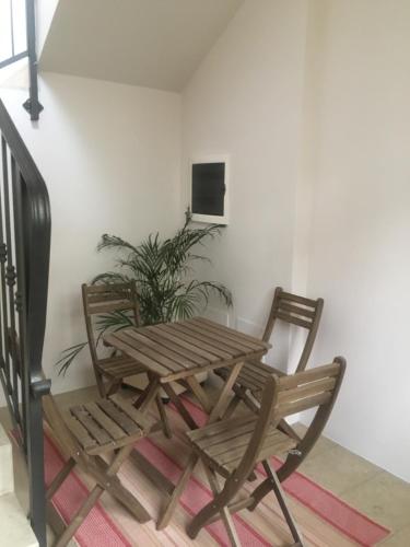 une table et des chaises en bois dans une pièce avec une plante dans l'établissement Appartamento nuovo e luminoso, à Padoue