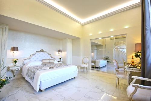 a bedroom with a white bed and a desk and a room at The Moon Boutique Hotel & Spa in Florence