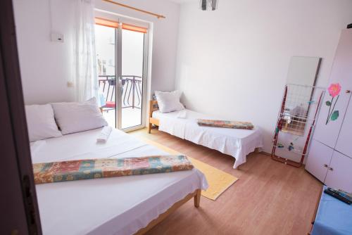 a small room with two beds and a balcony at Villa Šutić in Promajna