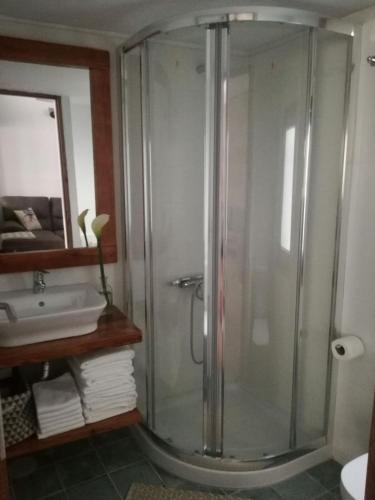 a bathroom with a glass shower and a sink at Residencial LaMar in Santa Cruz de la Palma