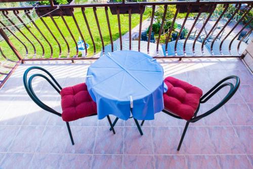 stół i dwa krzesła ze stołem i parasolem w obiekcie Villa Šutić w mieście Promajna