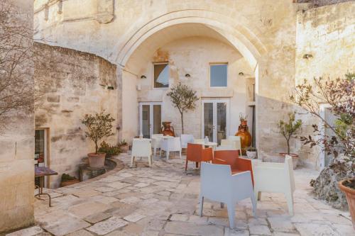 a room with a table, chairs, and tables at Hotel Sassi in Matera