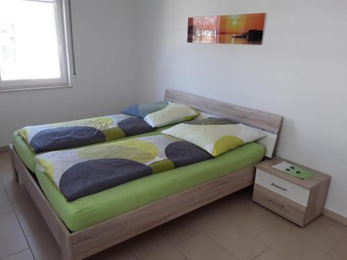a bed with a wooden frame with pillows on it at Haus am Leuchtfeuer in Peenemünde