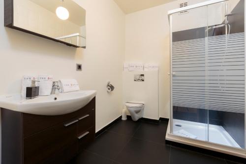 a bathroom with a sink and a shower and a toilet at The Queen Luxury Apartments - Villa Carlotta in Luxembourg