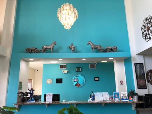 a mirror in a room with a blue wall at Howard Johnson by Wyndham Lubbock TX in Lubbock
