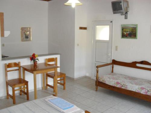 a bedroom with a bed and a table and a desk at Chris Apartments in Marathokampos