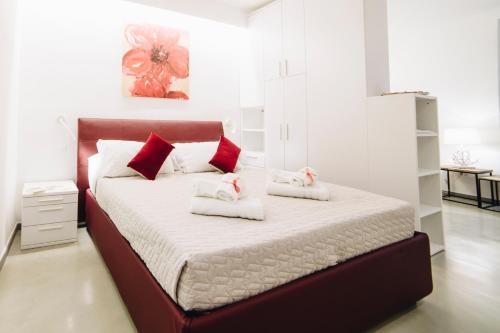 Schlafzimmer mit einem Bett mit roten und weißen Kissen in der Unterkunft 330 Holiday Apartments Manarola in Manarola