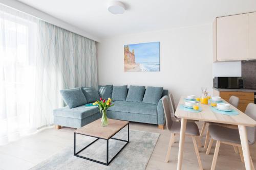 a living room with a blue couch and a table at Raval Apartments - Fresh Turquoise in Rewal
