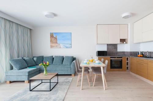 a living room with a blue couch and a table at Raval Apartments - Fresh Turquoise in Rewal