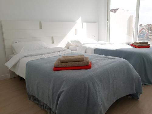 a room with three beds with towels on the bed at Villa Pinatar in San Pedro del Pinatar