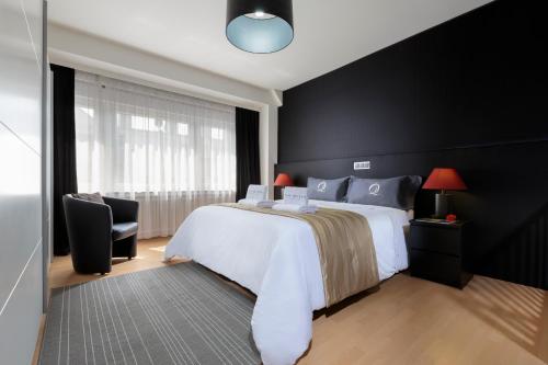 a bedroom with a white bed and a black wall at The Queen Luxury Apartments - Villa Carlotta in Luxembourg