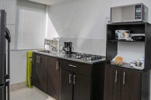 蒙特內格羅的住宿－construcciones Guaduales del café，厨房配有黑色橱柜和炉灶烤箱。