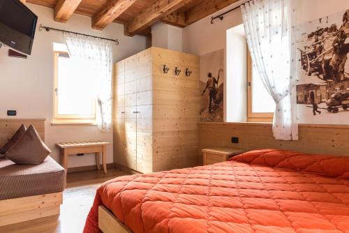 a bedroom with a bed and a television in it at Agritur La Polentera in Storo