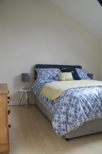 Schlafzimmer mit einem Bett mit blauer Decke in der Unterkunft Kyme Street, central York in York