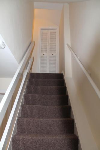 a staircase leading up to a white room with a door at Kyme Street, central York in York