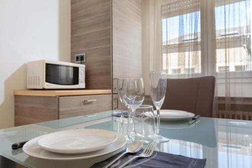 a dining table with plates and wine glasses on it at The Queen Luxury Apartments - Villa Carlotta in Luxembourg
