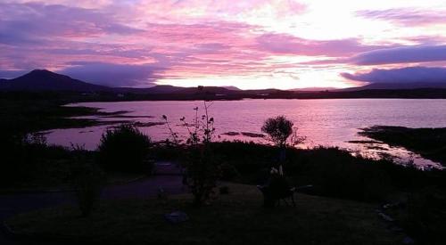 un tramonto su un grande corpo d'acqua di Rossroe Lodge B&B a Canower