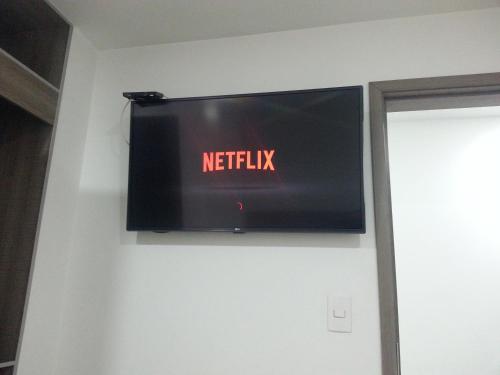 a television on a wall with the netflix sign on it at A Bogota On Holidays by Open - HOTEL CAS-EMBAJADA AMERICANA in Bogotá