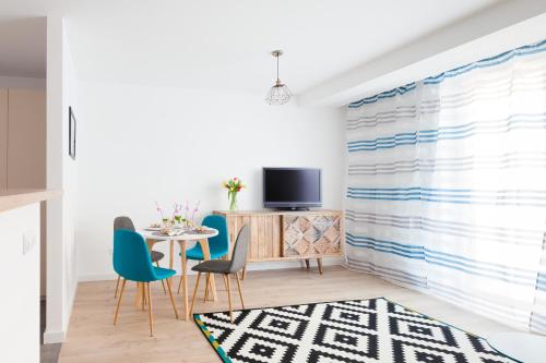 レバルにあるRaval Apartments - Light Blueのダイニングルーム(テーブル、椅子、テレビ付)