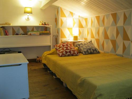 a bedroom with a large bed with two pillows on it at Les Violettes in Mons
