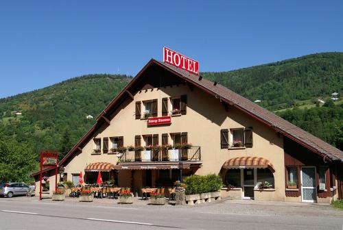 a hotel building with a sign on the top of it at Auberge Alsacienne in Bussang