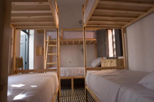 two beds in a room with two bunk beds at Boho 27 Hostel Marrakech in Marrakech