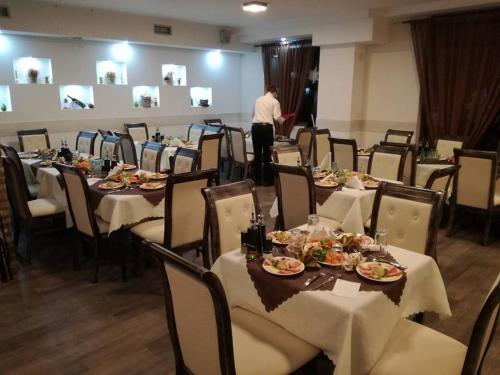 a man standing in front of a dining room with tables at Hotel Scorpion in Kruševo