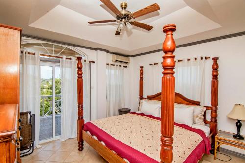 a bedroom with a bed and a ceiling fan at Paradise Cove in Gros Islet
