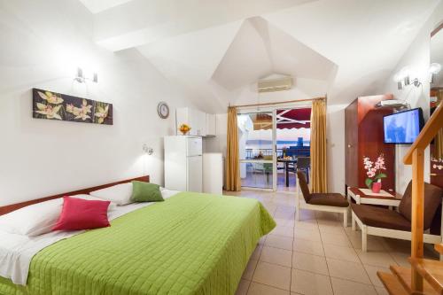 a bedroom with a bed with a green bedspread at Vila Nela in Tučepi