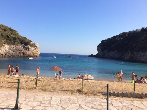 a group of people on a beach near the water at Villa Ampelaki 2 in Paleokastritsa