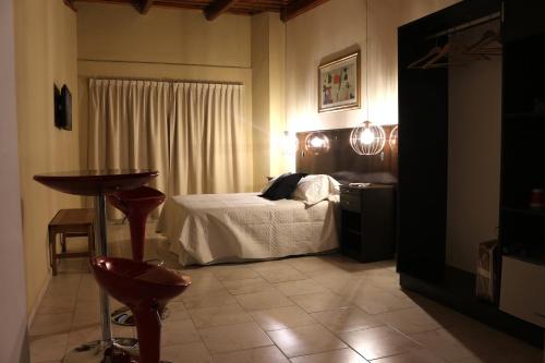 a bedroom with a bed and a table in a room at Eclat Suites Hotel Boutique in Villa Mercedes