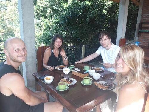 a group of people sitting around a table eating food at Sugi Gede Homestay in Singaraja