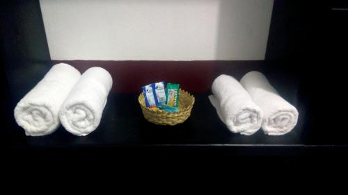 a shelf with towels and a basket of toothbrushes at Hotel Falcon in Tamasopo