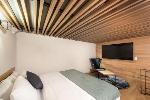 a bedroom with a bed and a flat screen tv at Delight Hotel Jamsil in Seoul