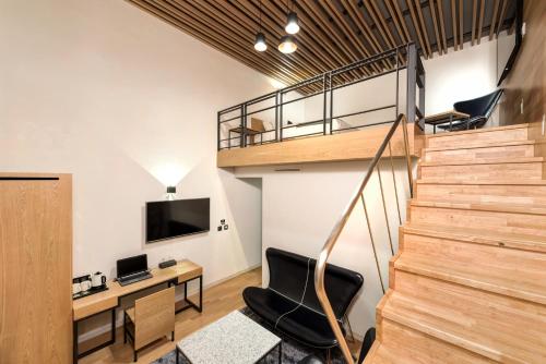 a room with a staircase and a desk and a chair at Delight Hotel Jamsil in Seoul