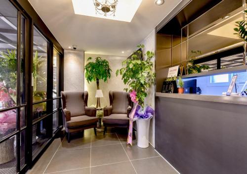 a waiting room with two chairs and plants at French code Hotel in Changwon