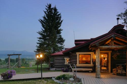 a log cabin with a tree in front of it at Buffalo Valley Ranch in Moran