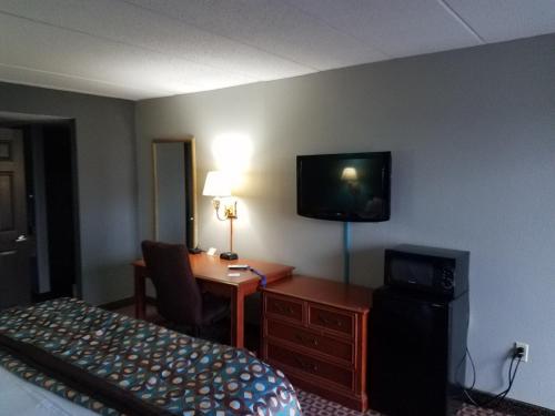 a hotel room with a bed and a desk and a television at Americas Best Value Inn St. Louis Downtown in Saint Louis