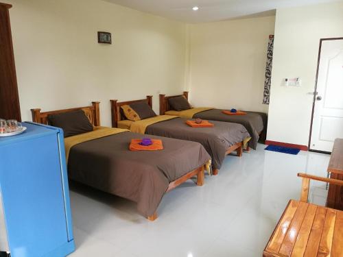 eine Gruppe von 4 Betten in einem Zimmer in der Unterkunft P and P Place in Kanchanaburi