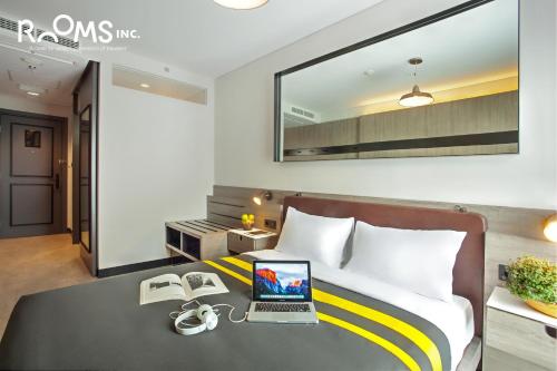 a bedroom with a bed with a laptop on a desk at Rooms Inc Semarang in Semarang