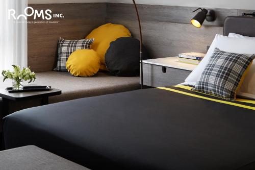 a bedroom with a bed and a couch with pillows at Rooms Inc Semarang in Semarang
