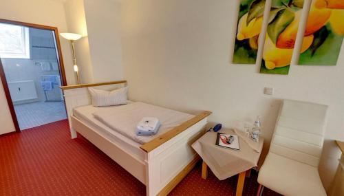 a small room with a bed and a table at Heidekönig Hotel Celle in Celle