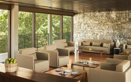 a living room with couches and tables and windows at Jetwing Lake in Dambulla