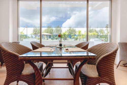 a dining room with a table and chairs and a large window at Grandvrio Resort Saipan in Garapan
