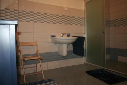 a bathroom with a sink and a chair at Chalupa u kostela in Lukov