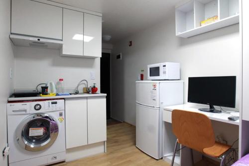 a white kitchen with a washing machine and a washer at Laketel in Seoul