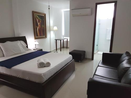 a bedroom with a bed and a couch at Palmagua in Barranquilla
