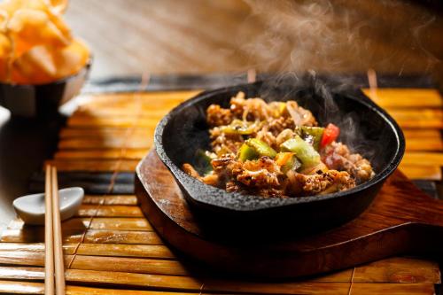 a bowl of food on a table with smoke at Jetwing Lake in Dambulla